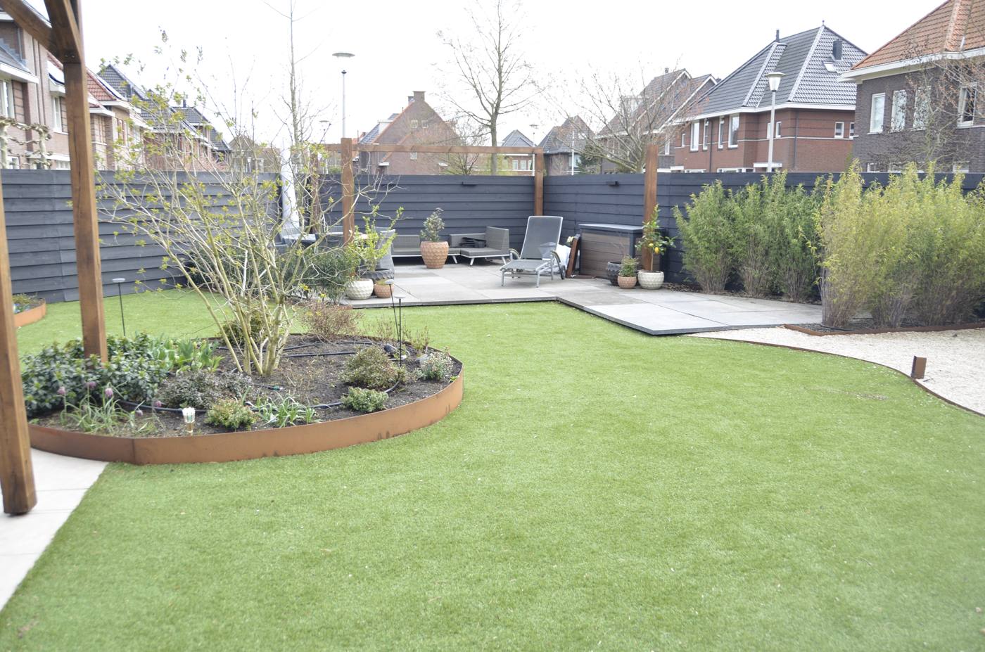 Ruim gazon met ronde border en terras, tuinontwerp Berkel en Rodenrijs