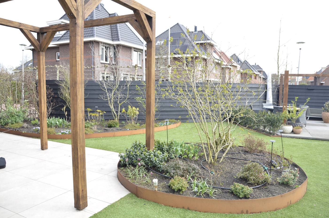 Houten pergola boven het terras met ronde border