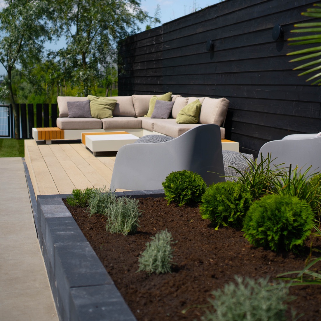 Buitenleven met loungehoek en terras in een aangelegde tuin